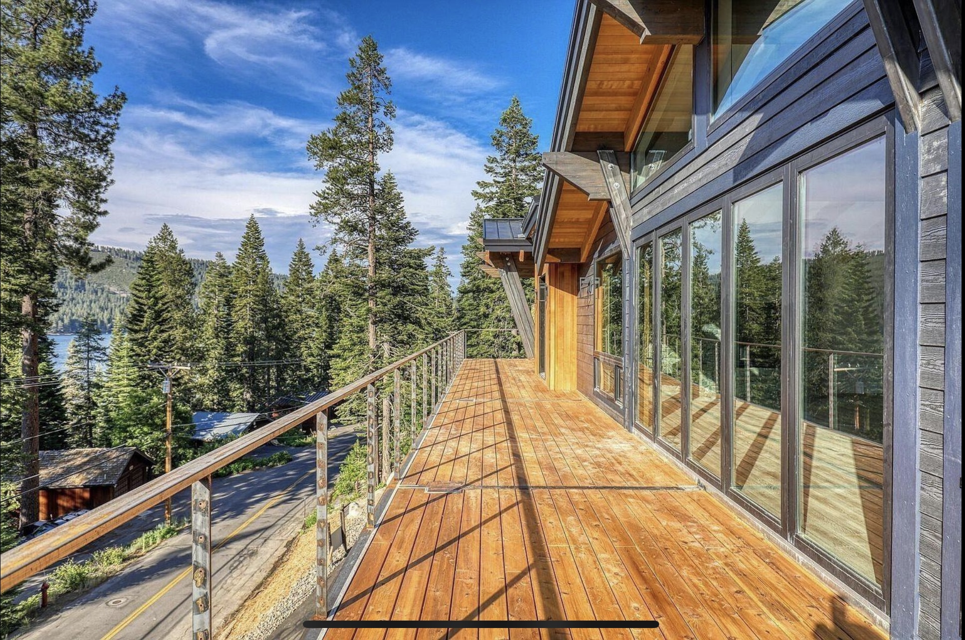 Timber deck with cable railing extending beside the lake-facing windows