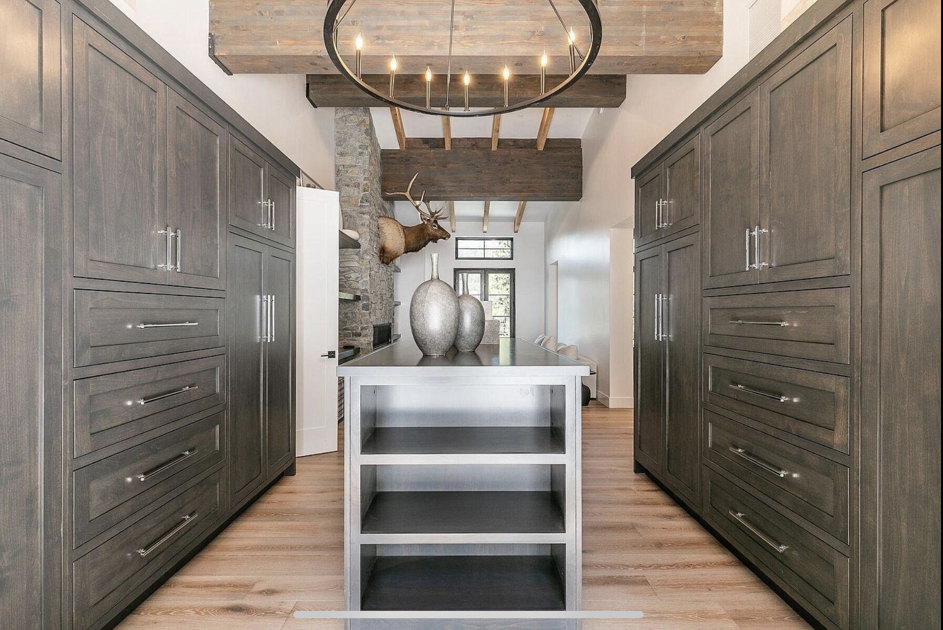 Dressing room with full-height dark cabinetry and a central storage island