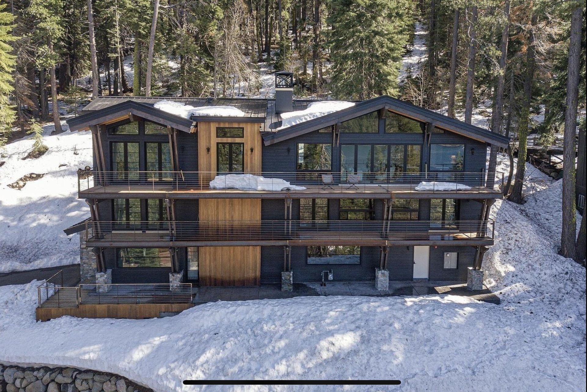 Donner Residence framed by snow and pines, with broad decks across the exterior
