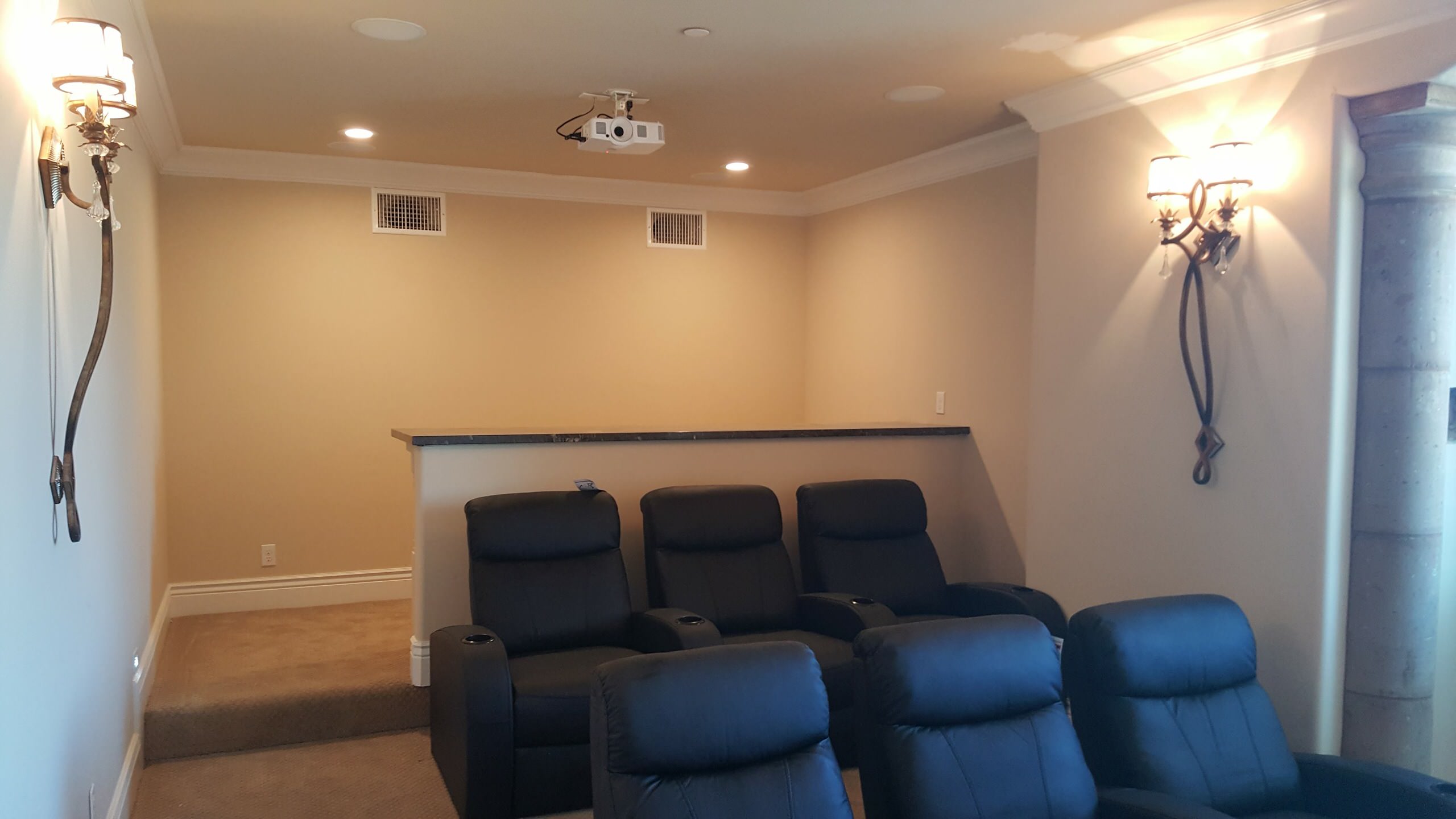 Dedicated home theater with reclining seats and wall sconces