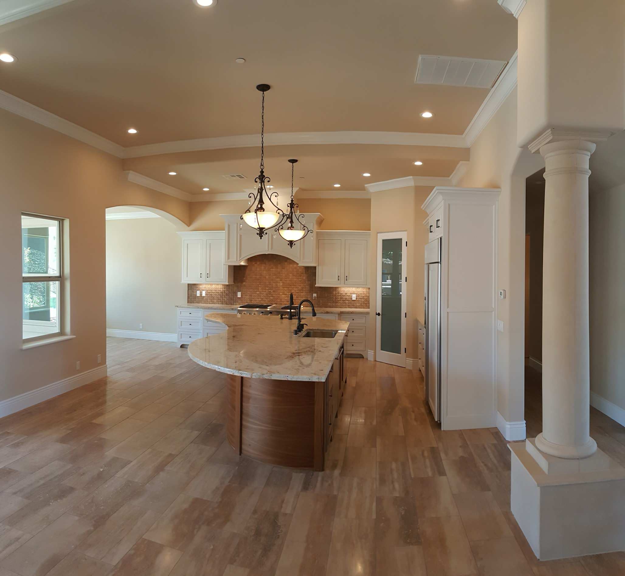 Open kitchen framed by columns and a tray ceiling
