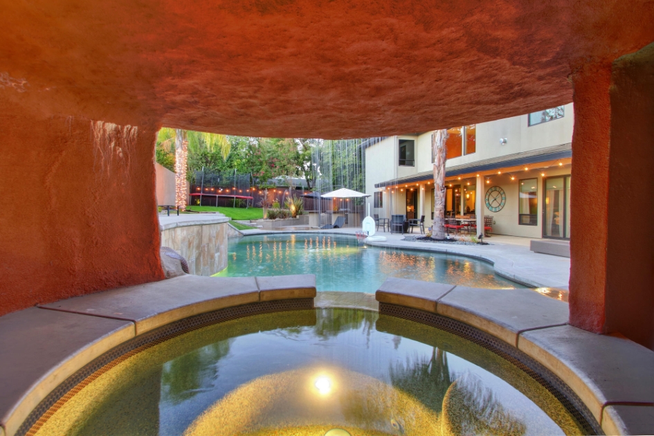 Sheltered spa beneath the waterfall feature