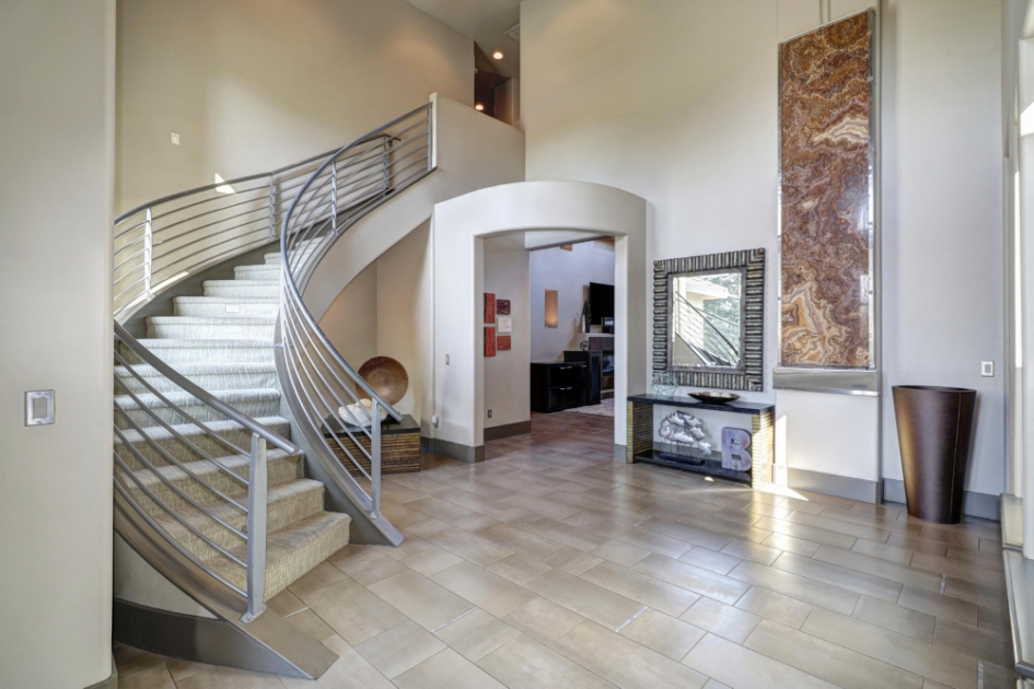 Sweeping staircase beside the double-height entry