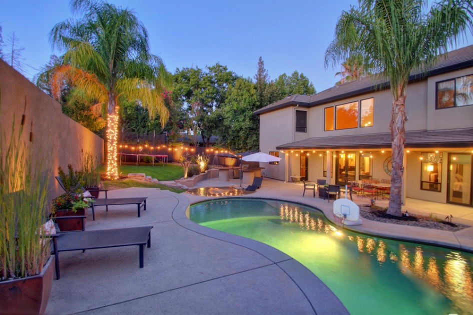 Pool courtyard at dusk with palms and outdoor seating