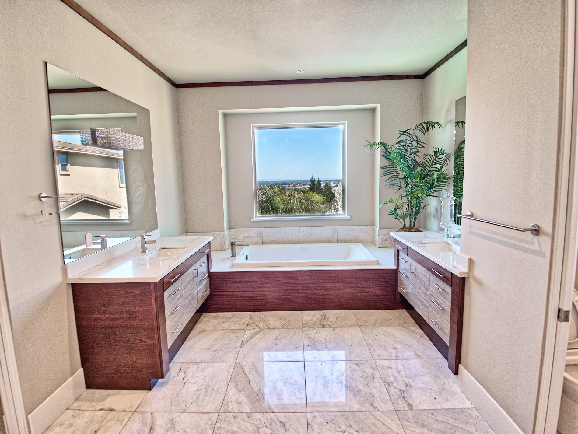 Primary bathroom with dual vanities and a view-facing soaking tub