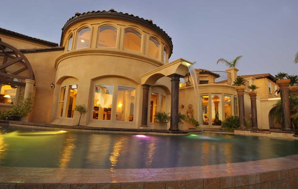 Rear elevation reflected across the pool at dusk